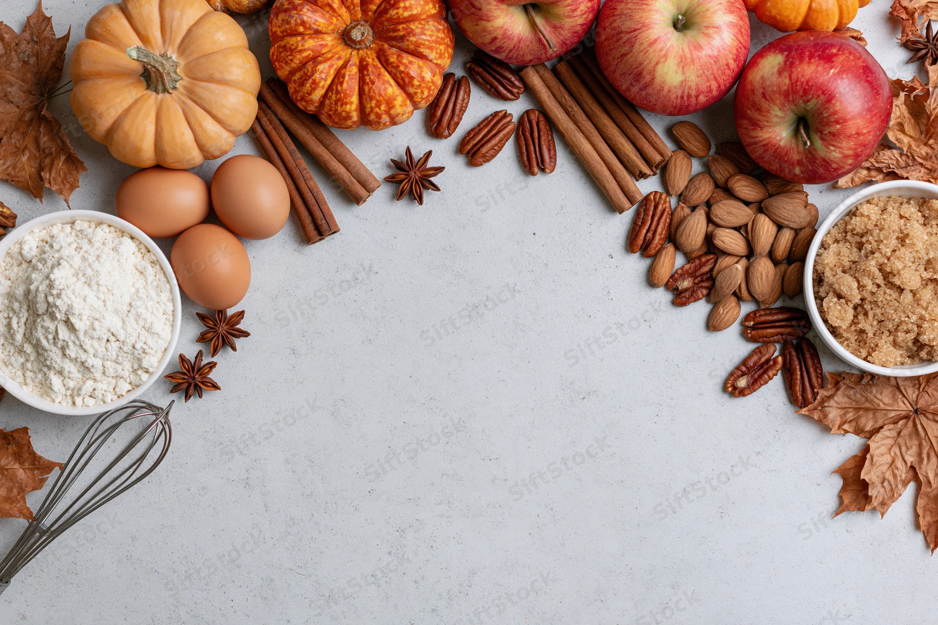 Autumn baking ingredients arranged on white surface with copyspace