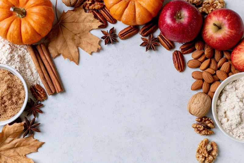 Autumn ingredients arranged around a white surface with copyspace