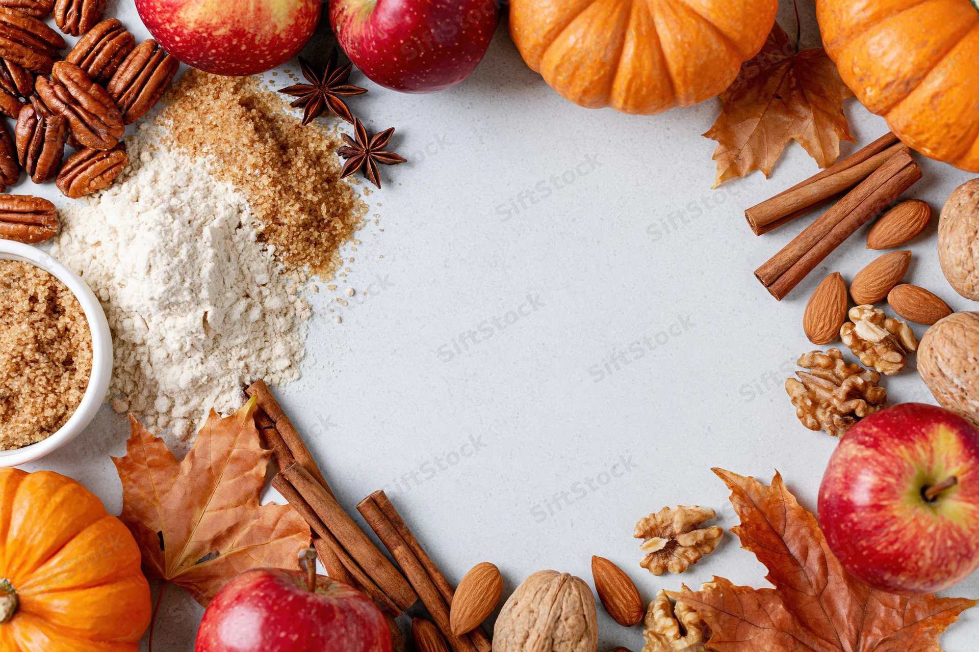 Autumn ingredients arranged in a frame around a white surface with copyspace