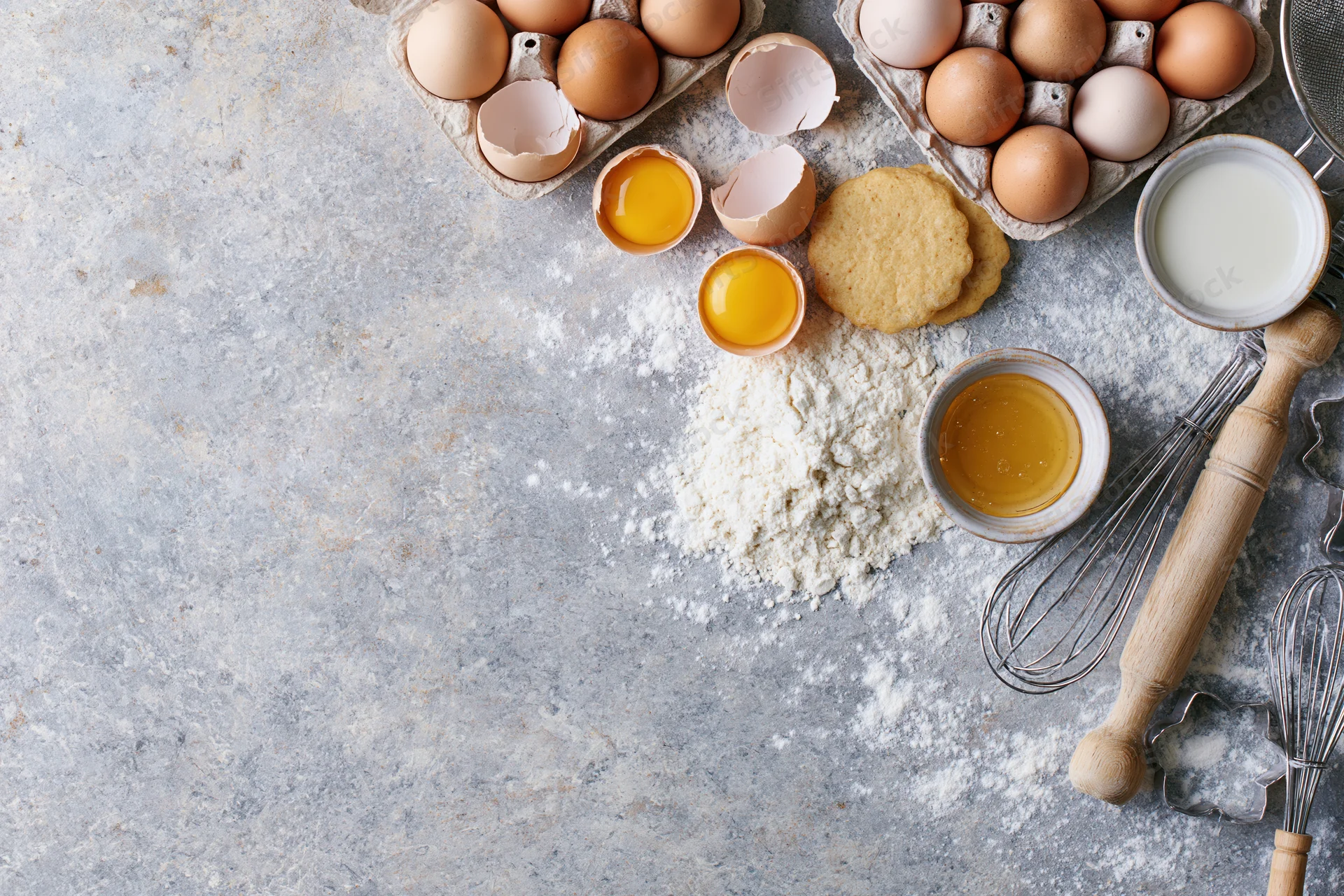 Baking ingredients arranged on a floured countertop with copyspace