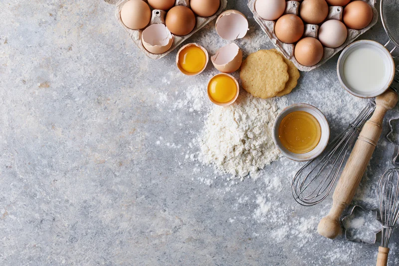 Baking ingredients arranged on a floured countertop with copyspace
