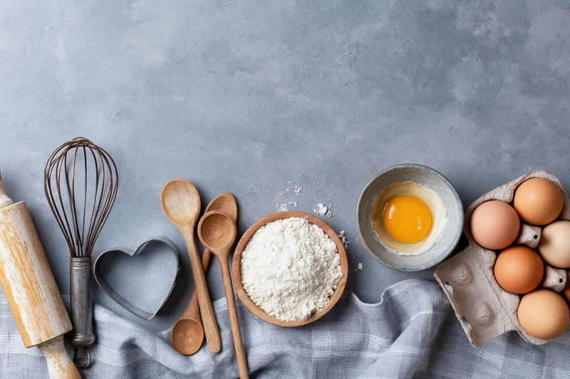 Baking ingredients and utensils arranged on a gray countertop with copyspace