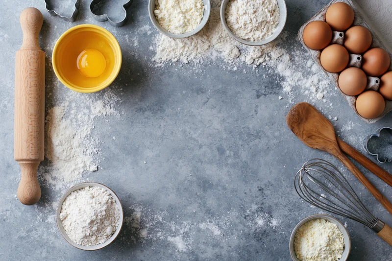 Baking ingredients arranged on a gray countertop with copyspace in center