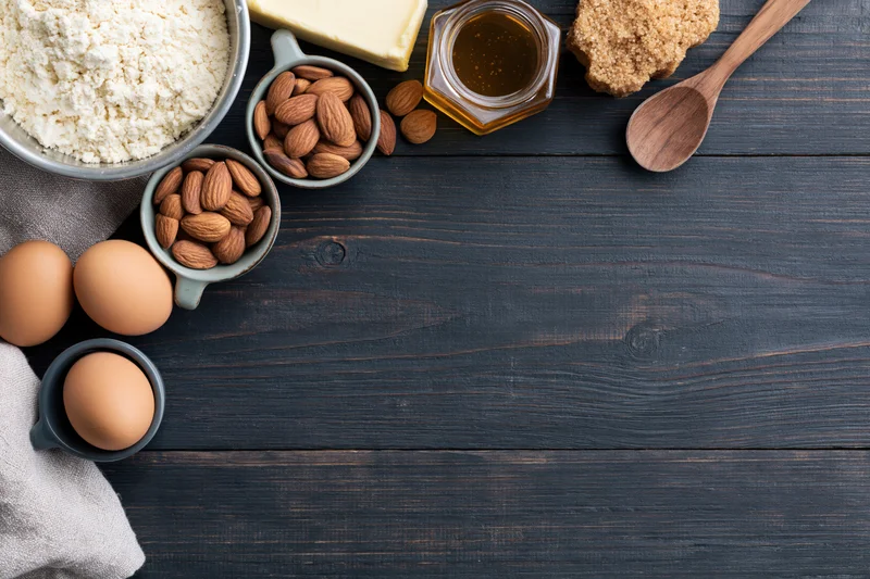 Baking ingredients arranged on dark wooden table with copyspace