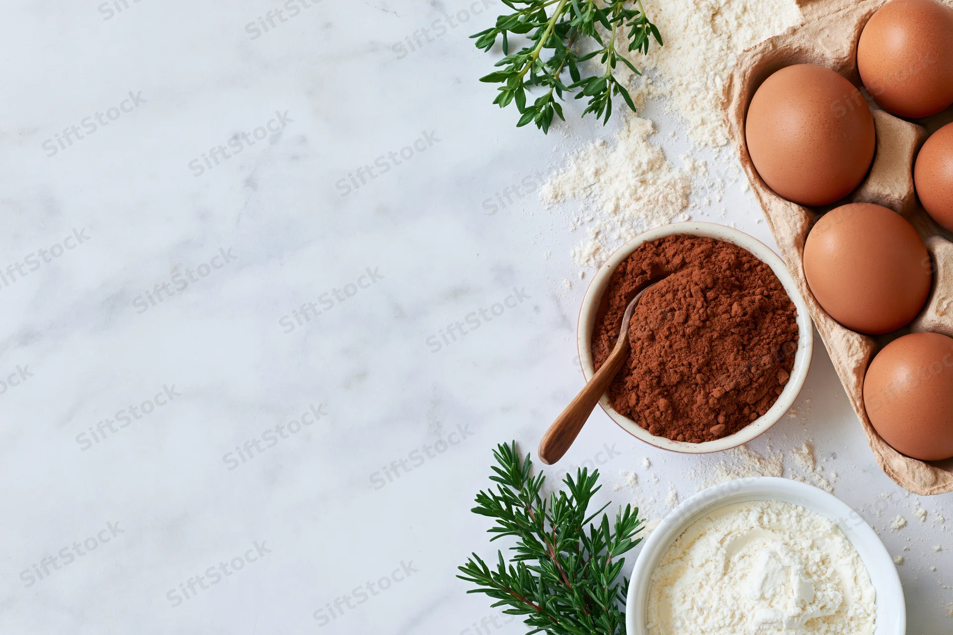 Baking ingredients arranged on a marble countertop with copyspace