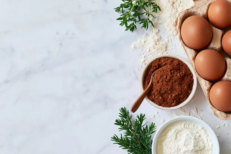 Baking ingredients arranged on a marble countertop with copyspace