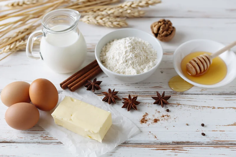 Baking ingredients arranged on a white wooden table with copyspace
