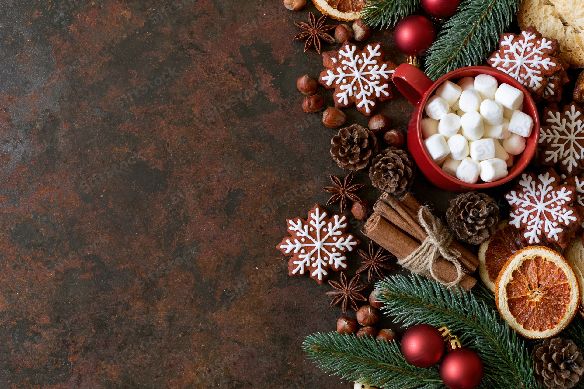 Christmas decorations and treats arranged on a dark textured surface with copyspace