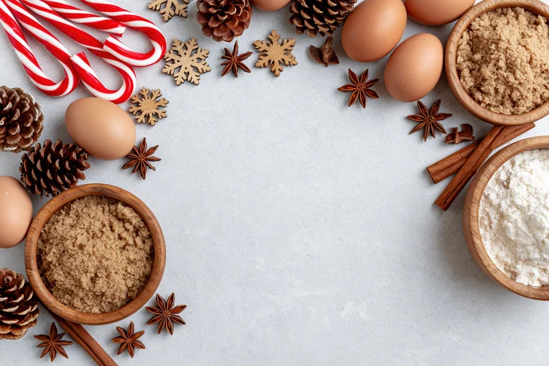Christmas baking ingredients arranged around the edges of a countertop with copyspace in the center