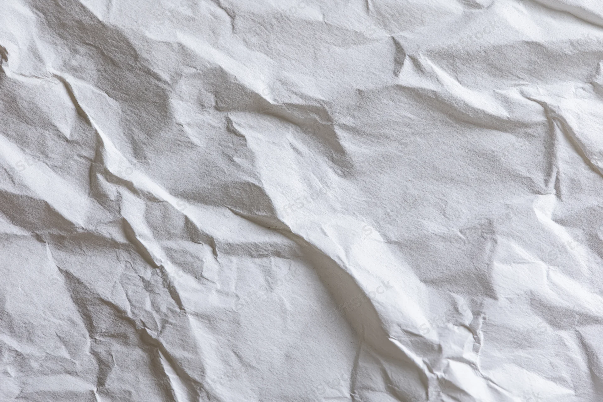 Crumpled white paper texture filling the frame with folds and creases