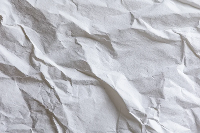 Crumpled white paper texture filling the frame with folds and creases