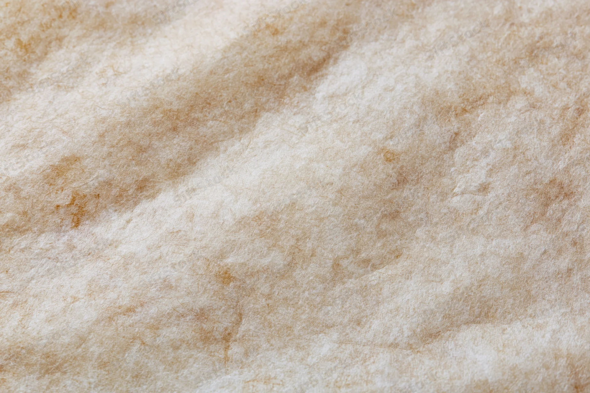 Closeup of beige wool felt fabric texture with soft fibrous surface