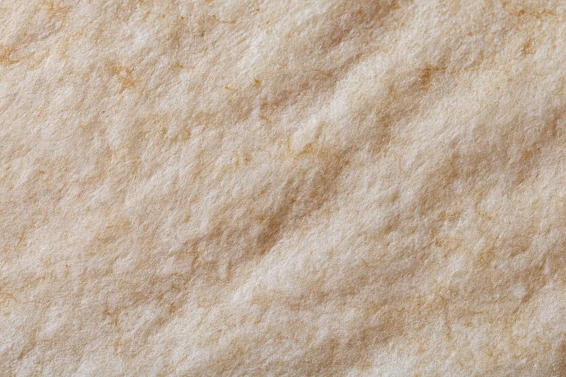 Close-up of textured beige paper surface with natural fibers and subtle creases