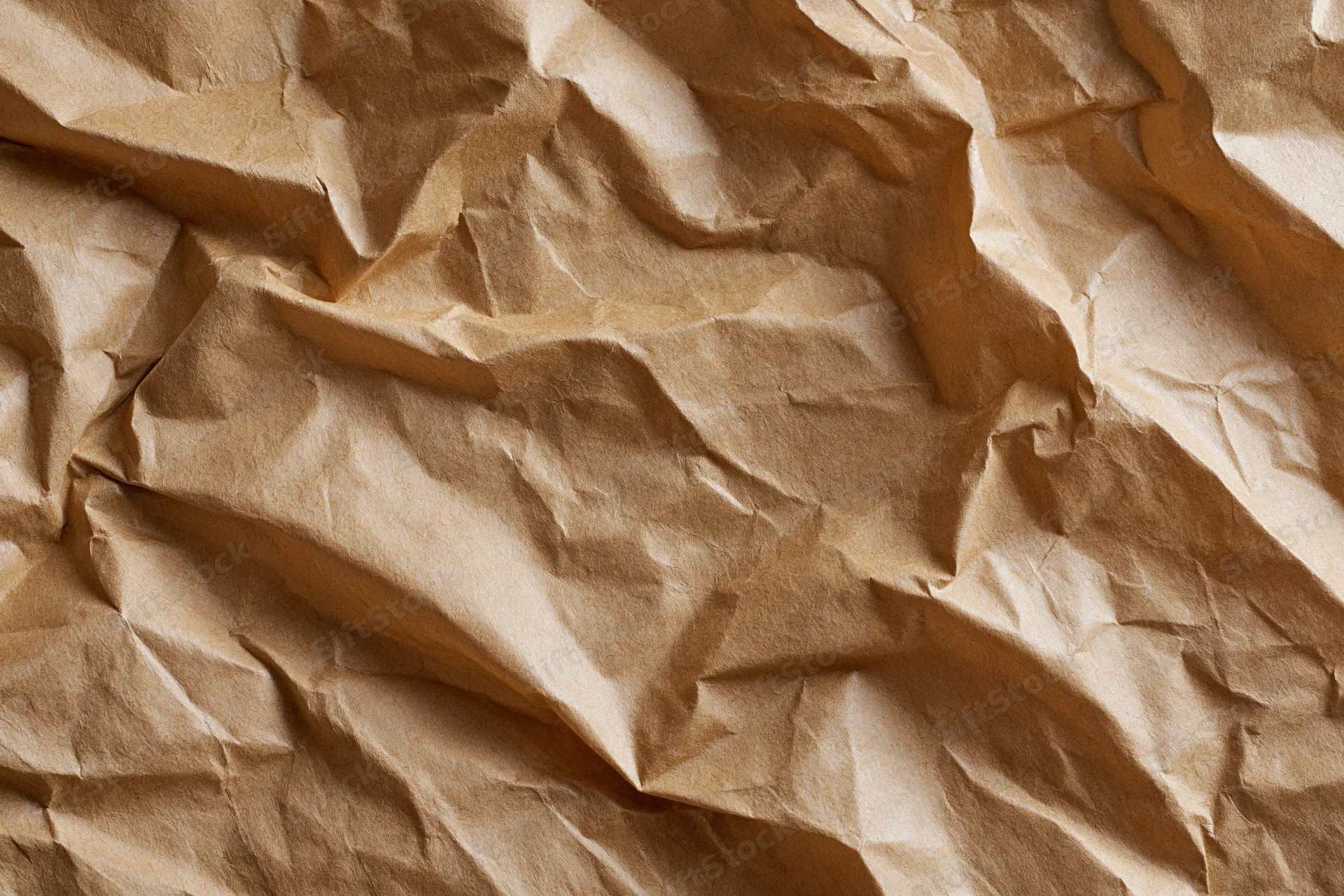 Crumpled brown paper texture filling the frame with folds and creases
