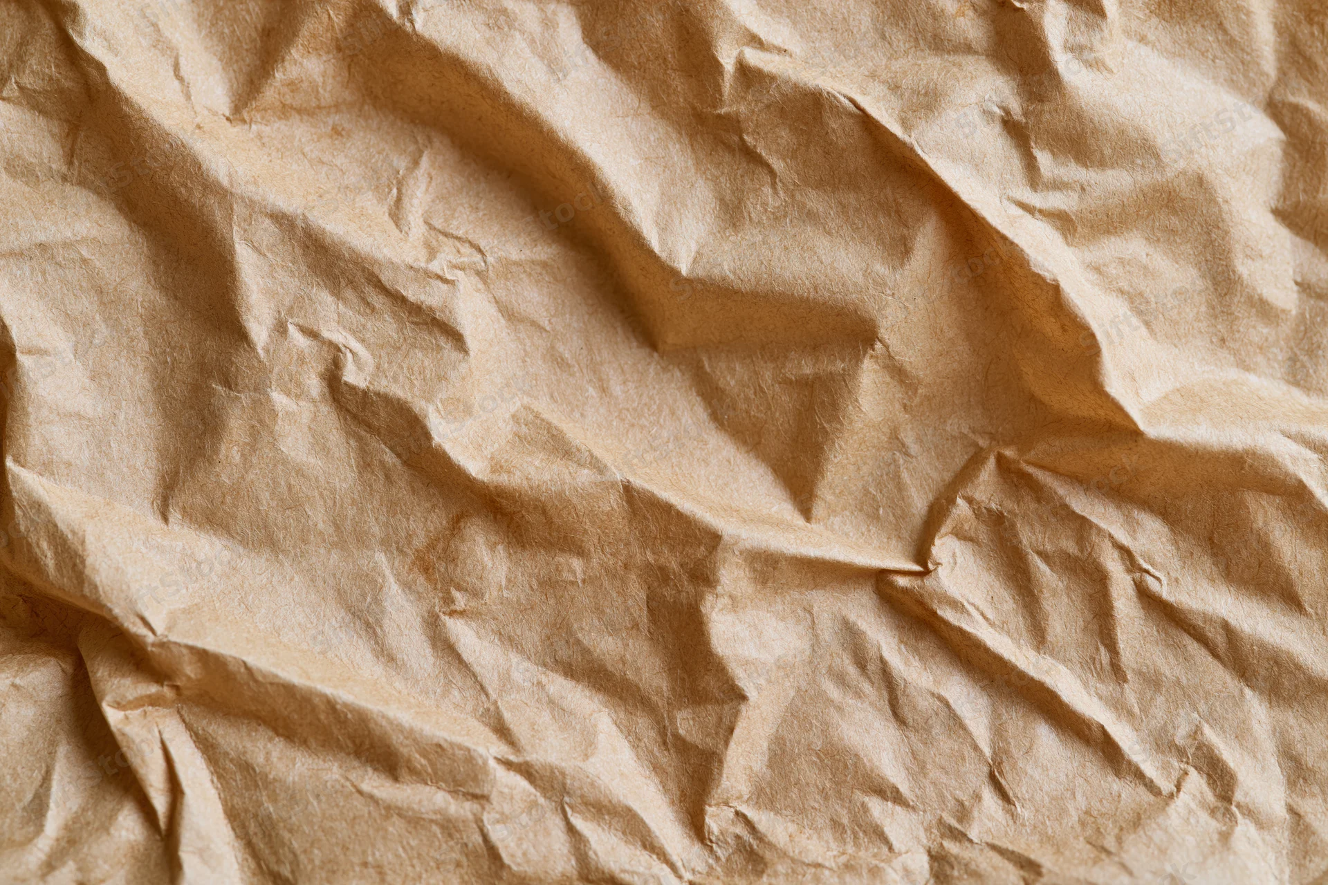 Crumpled brown paper texture filling the frame with natural folds and creases