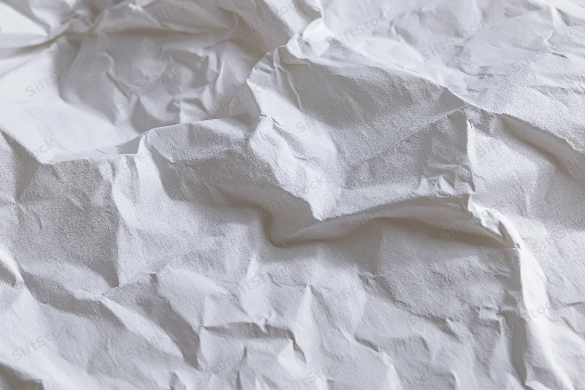 Crumpled white paper texture filling the frame with folds and creases