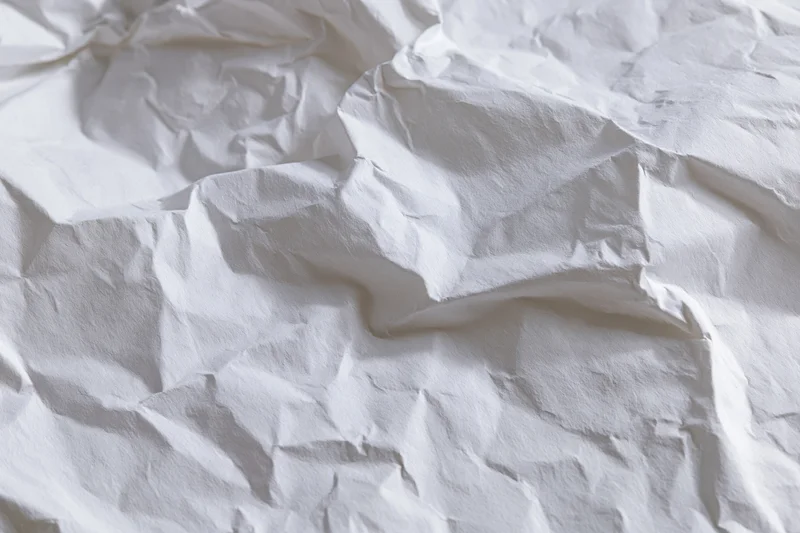 Crumpled white paper texture filling the frame with folds and creases