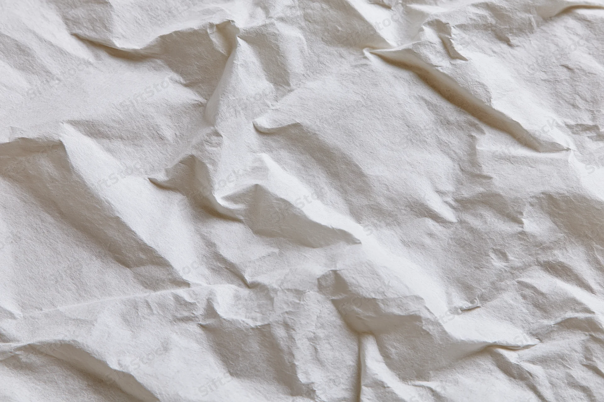Crumpled white paper texture filling the frame with folds and creases