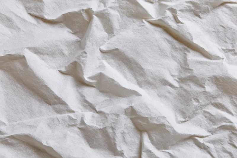 Crumpled white paper texture filling the frame with folds and creases