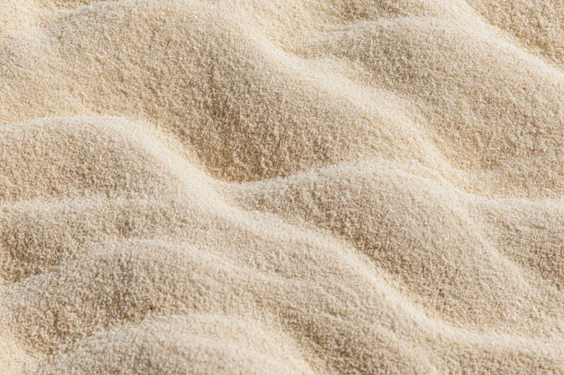 Closeup of beige plush carpet with undulating texture and soft shadows