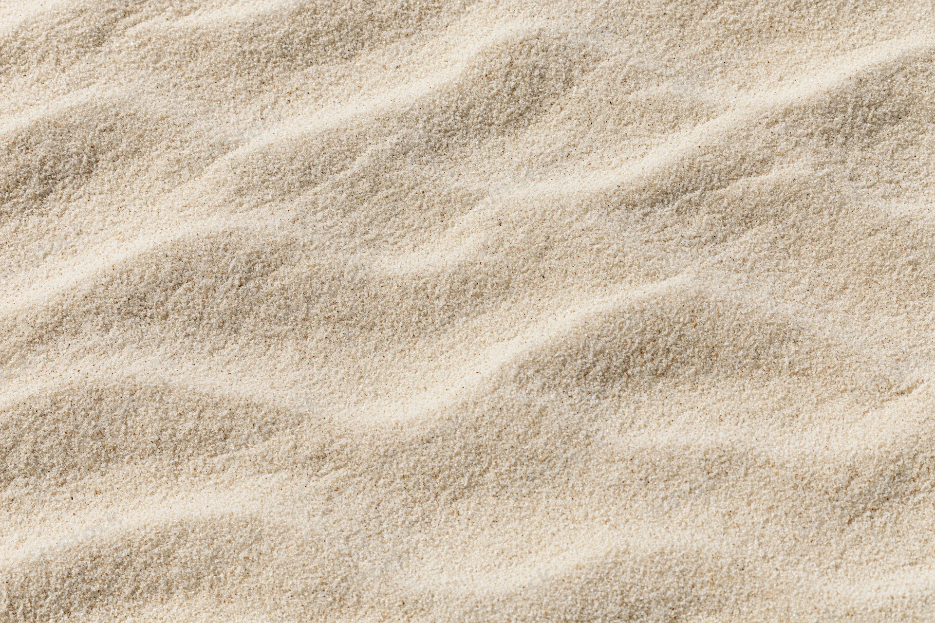 Closeup of rippled sand surface with natural texture and soft lighting