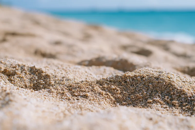 Closeup of textured sand on a beach with ocean in the background