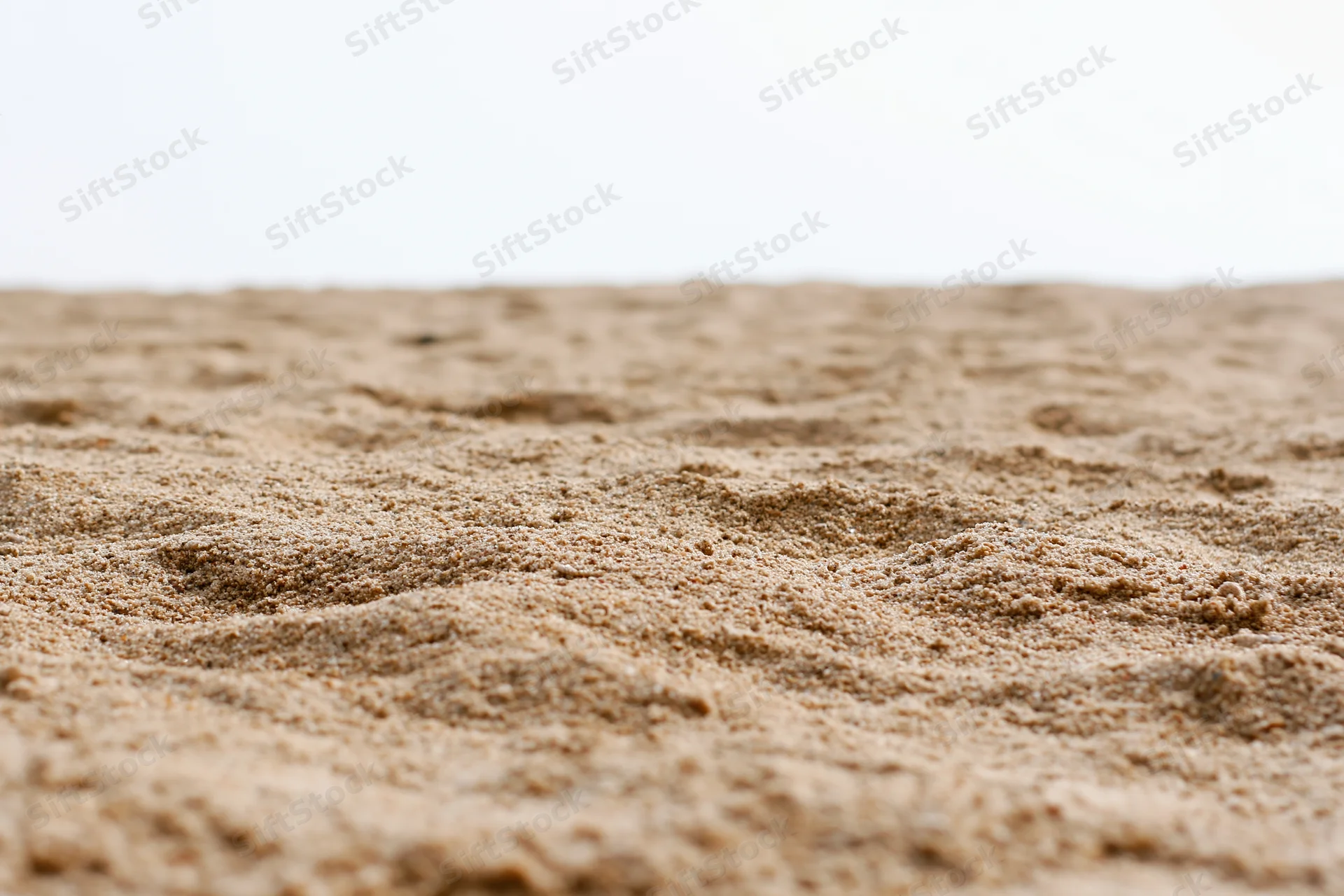 Closeup of textured sand surface against white background