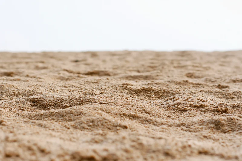 Closeup of textured sand surface against white background