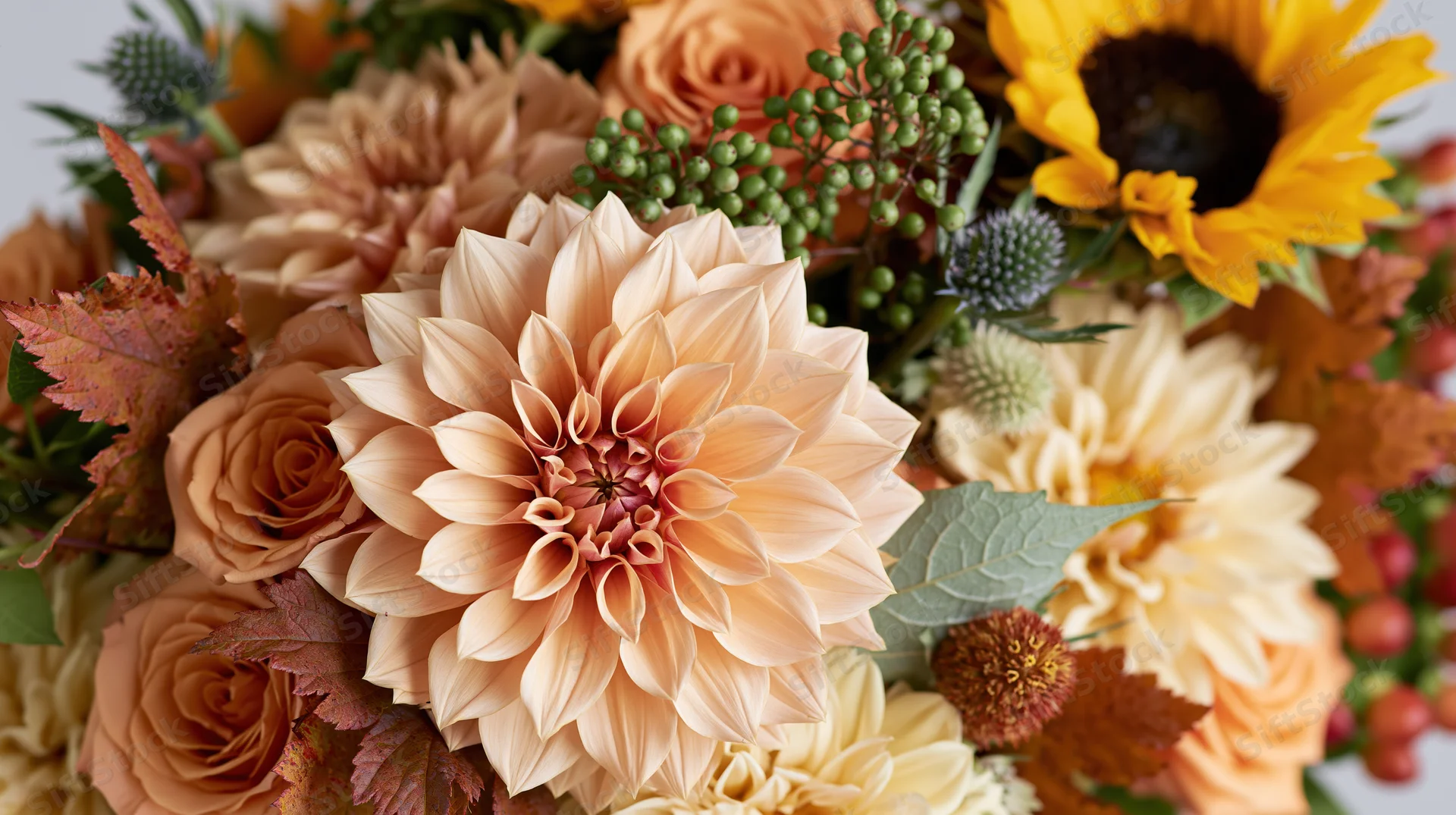 Close-up of a dahlia-centered autumn floral bouquet with sunflowers, roses, and foliage arranged in warm tones