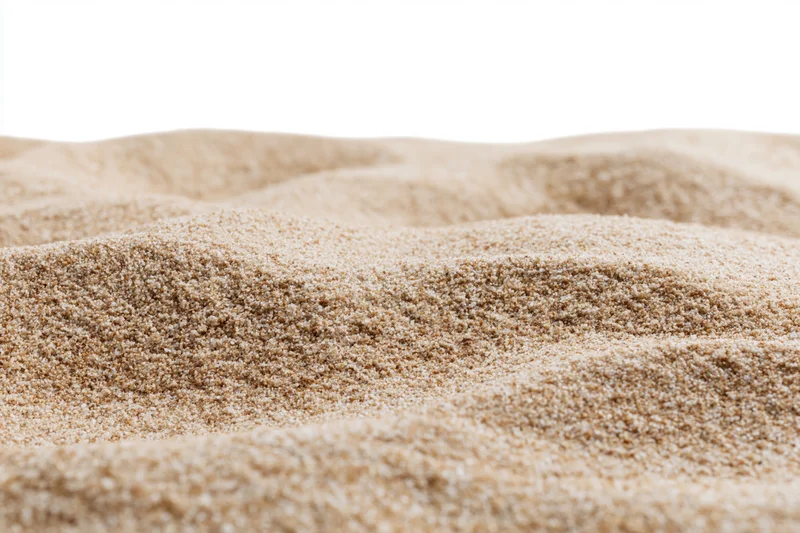 Closeup of textured sand surface with soft undulations on white background