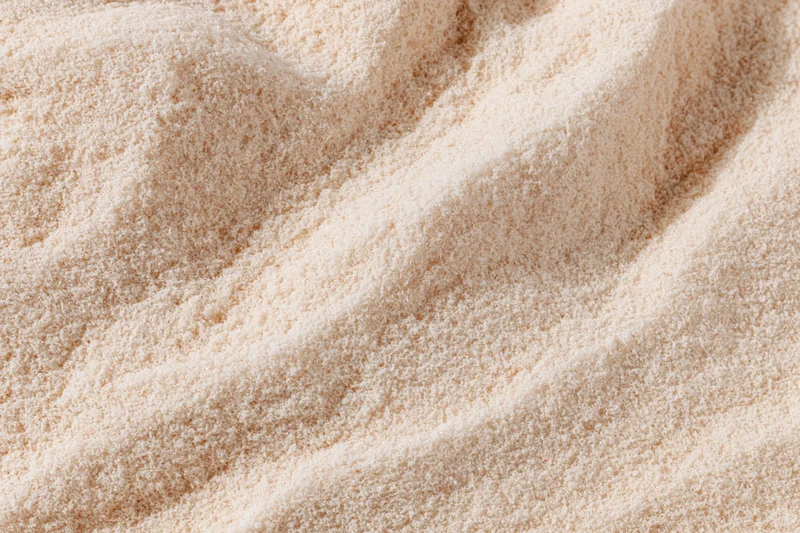 Closeup of fine white flour piled in soft waves showing texture and grain