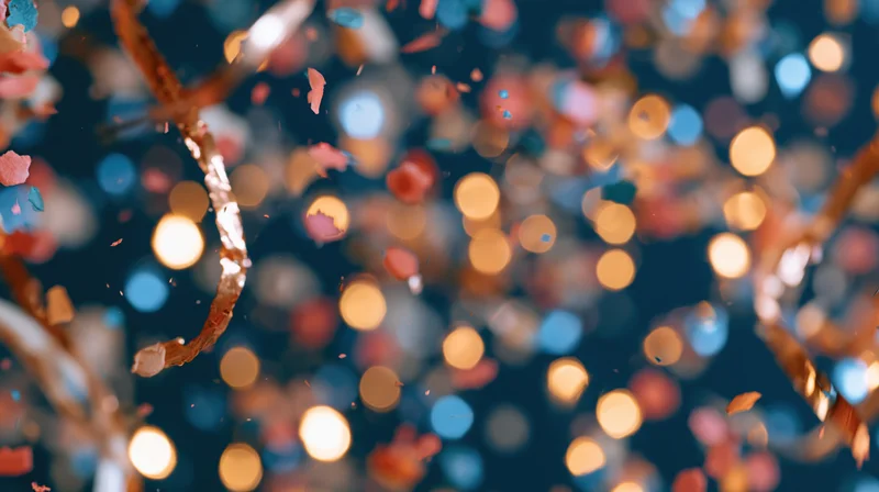 Confetti and bokeh lights floating in the air during a festive celebration at night