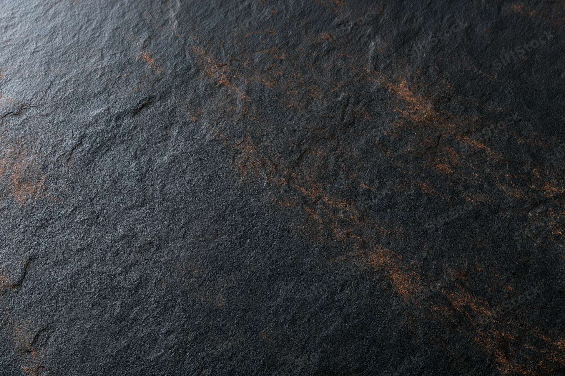Dark textured slate surface with natural veining and rough finish