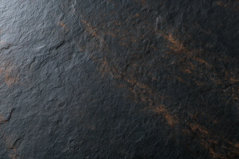 Dark textured slate surface with natural veining and rough finish