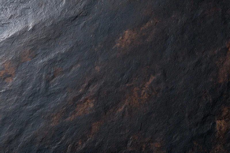 Dark weathered slate surface with rust stains and rough texture