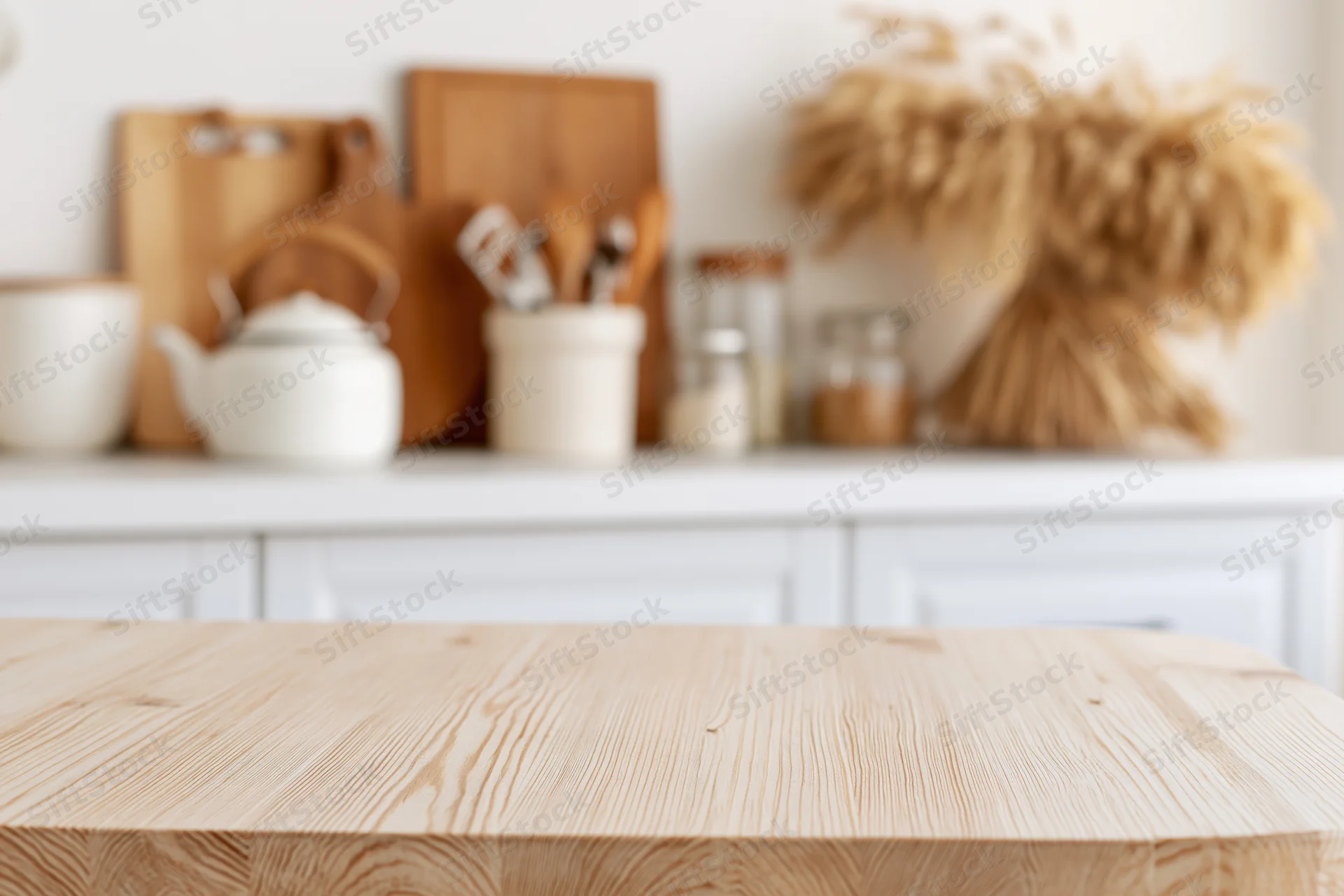 Wooden kitchen countertop in a bright home interior with blurred background of cooking tools and decor