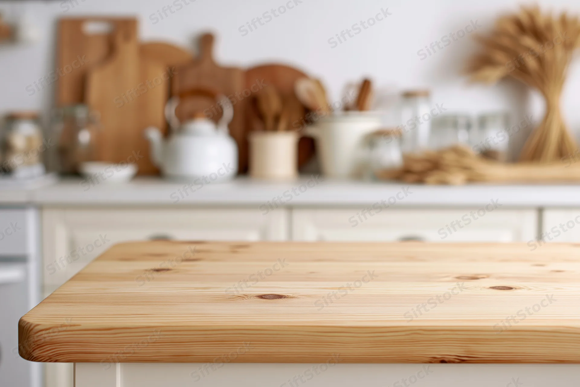 Wooden kitchen countertop in a bright home kitchen with blurred background of utensils and decor