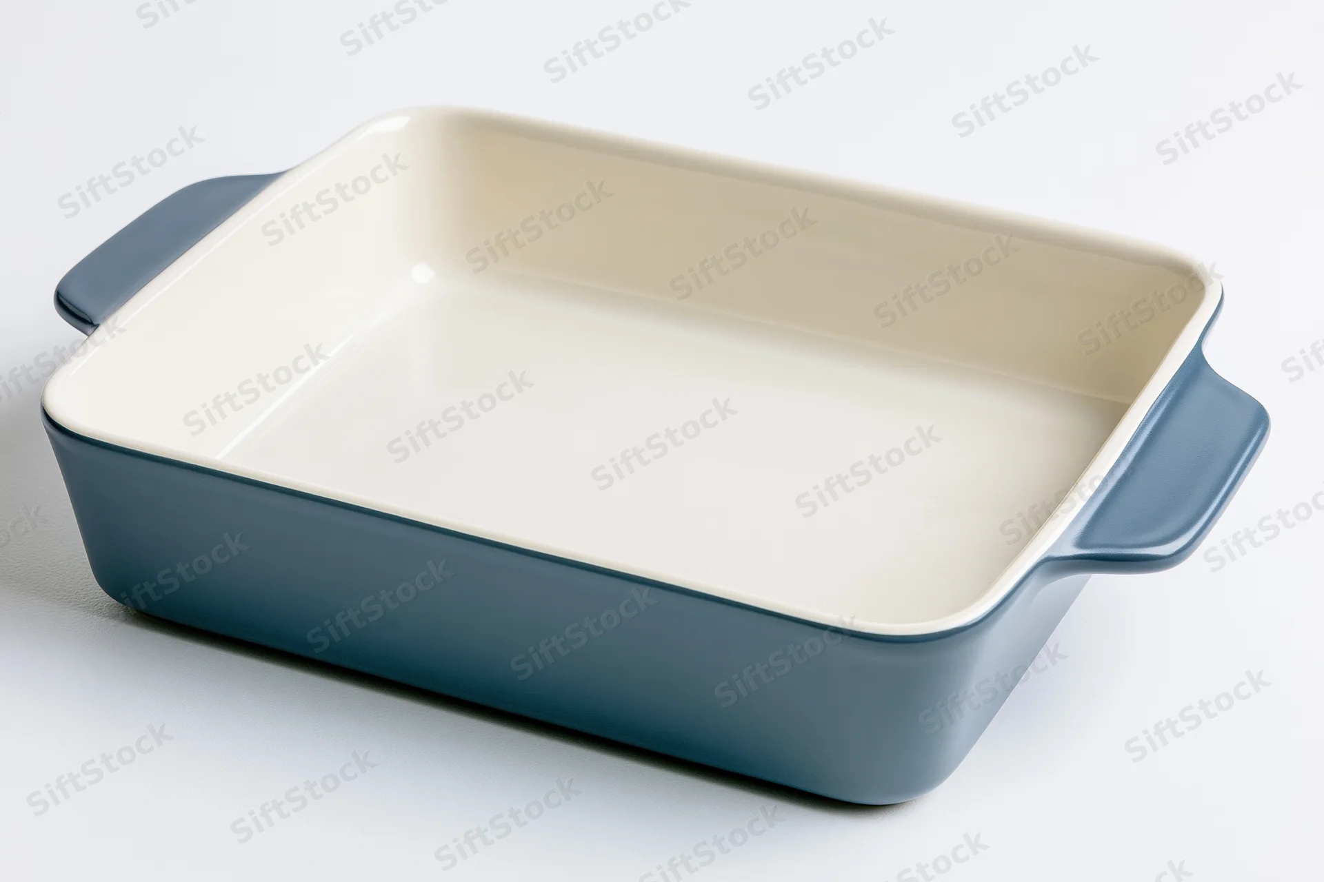 Blue ceramic baking dish with cream interior on white background