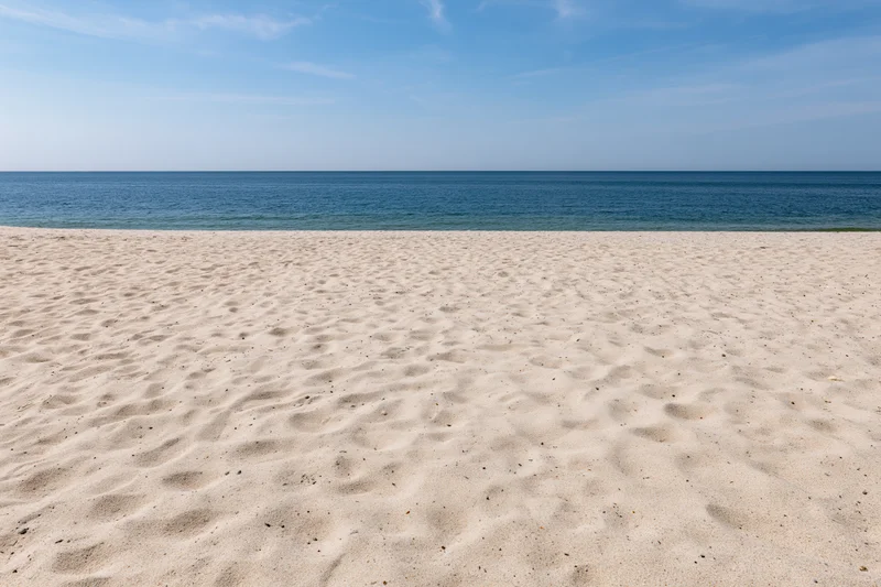 Sandy beach stretching to the ocean under a clear blue sky