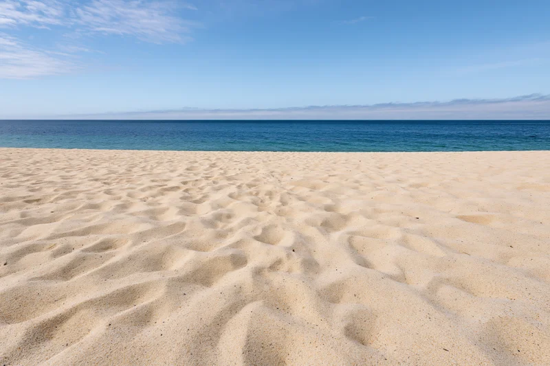 Sandy beach stretching to the ocean under a clear blue sky