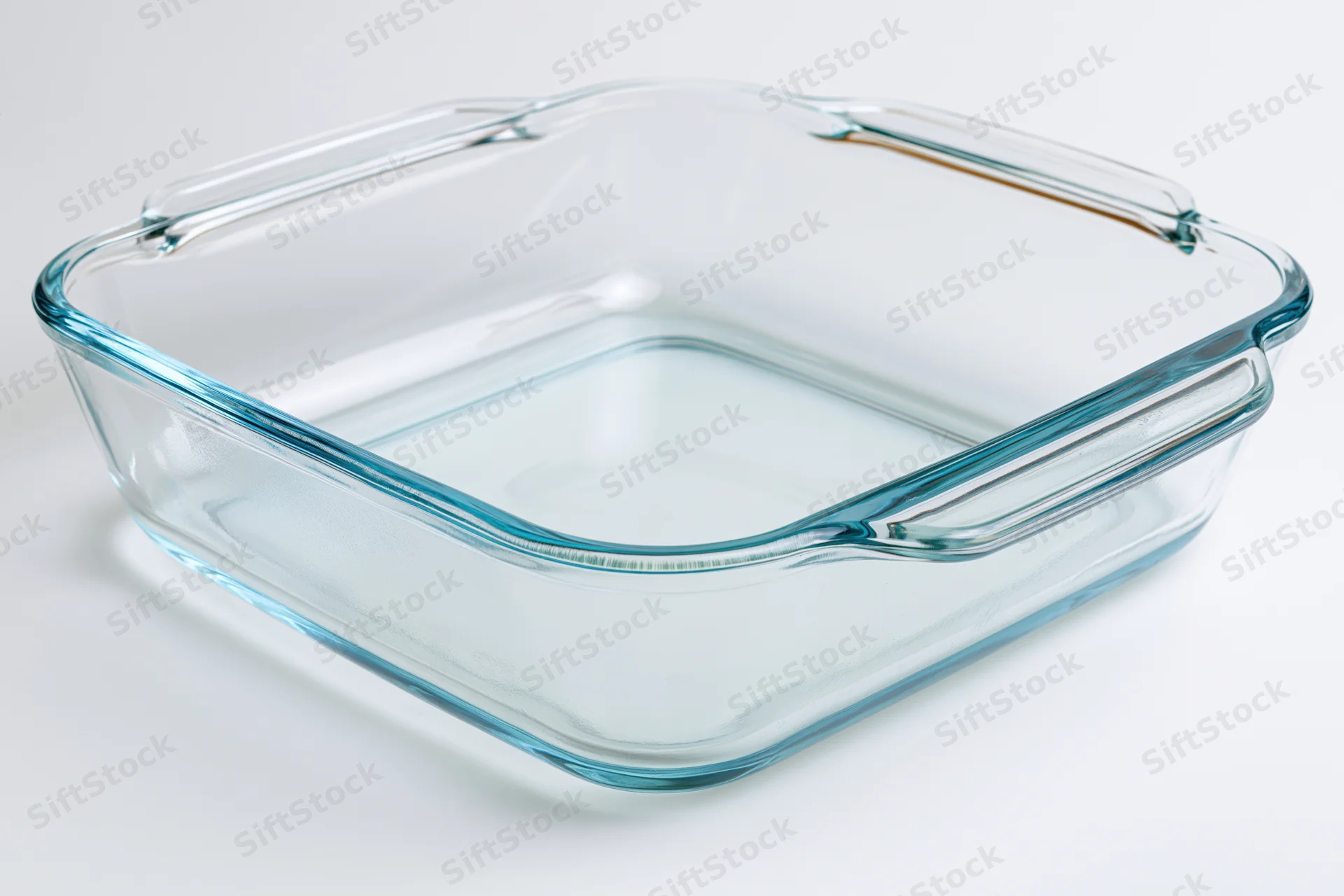 Transparent glass baking dish with blue rim on white background