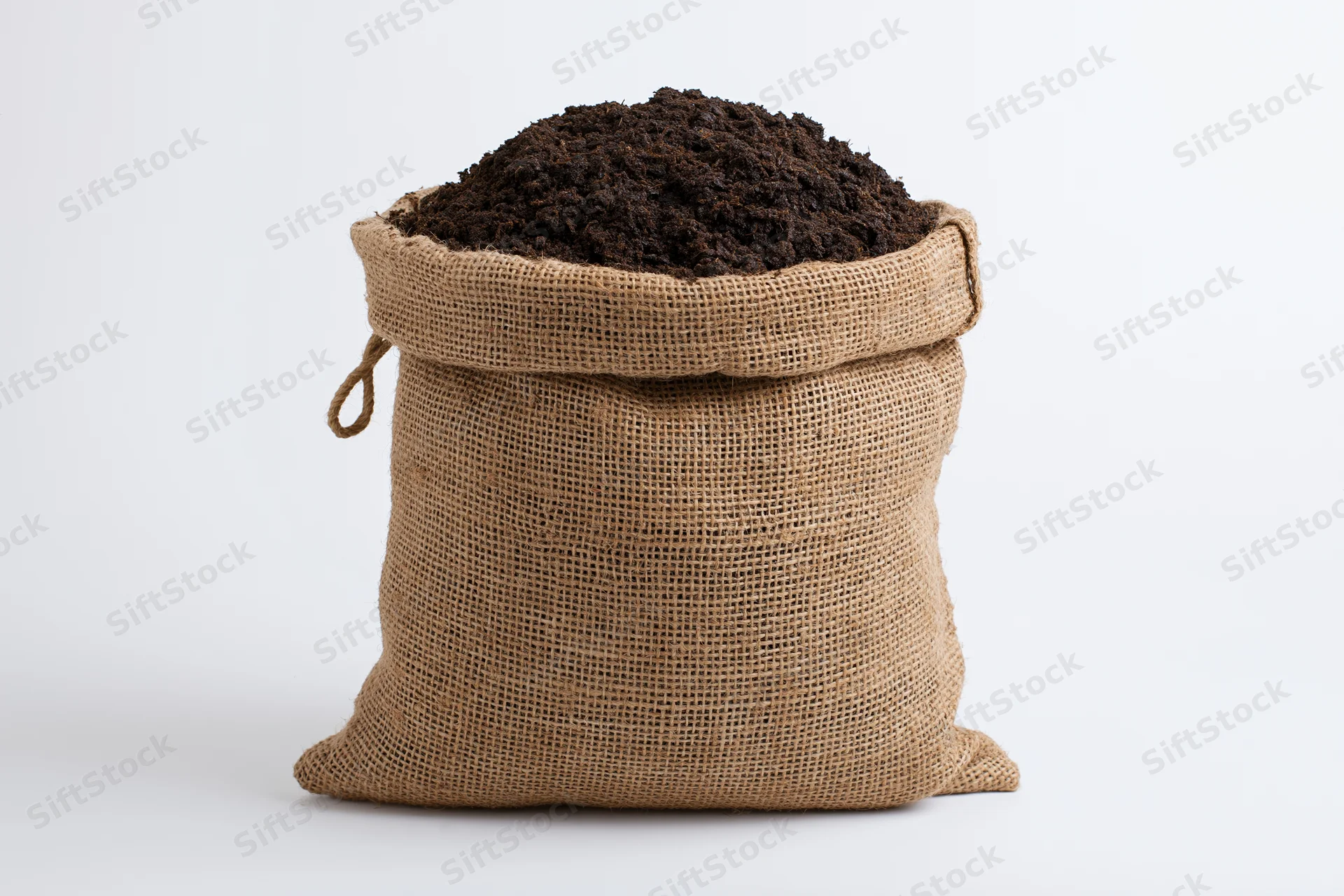Burlap sack filled with dark brown potting soil on white background