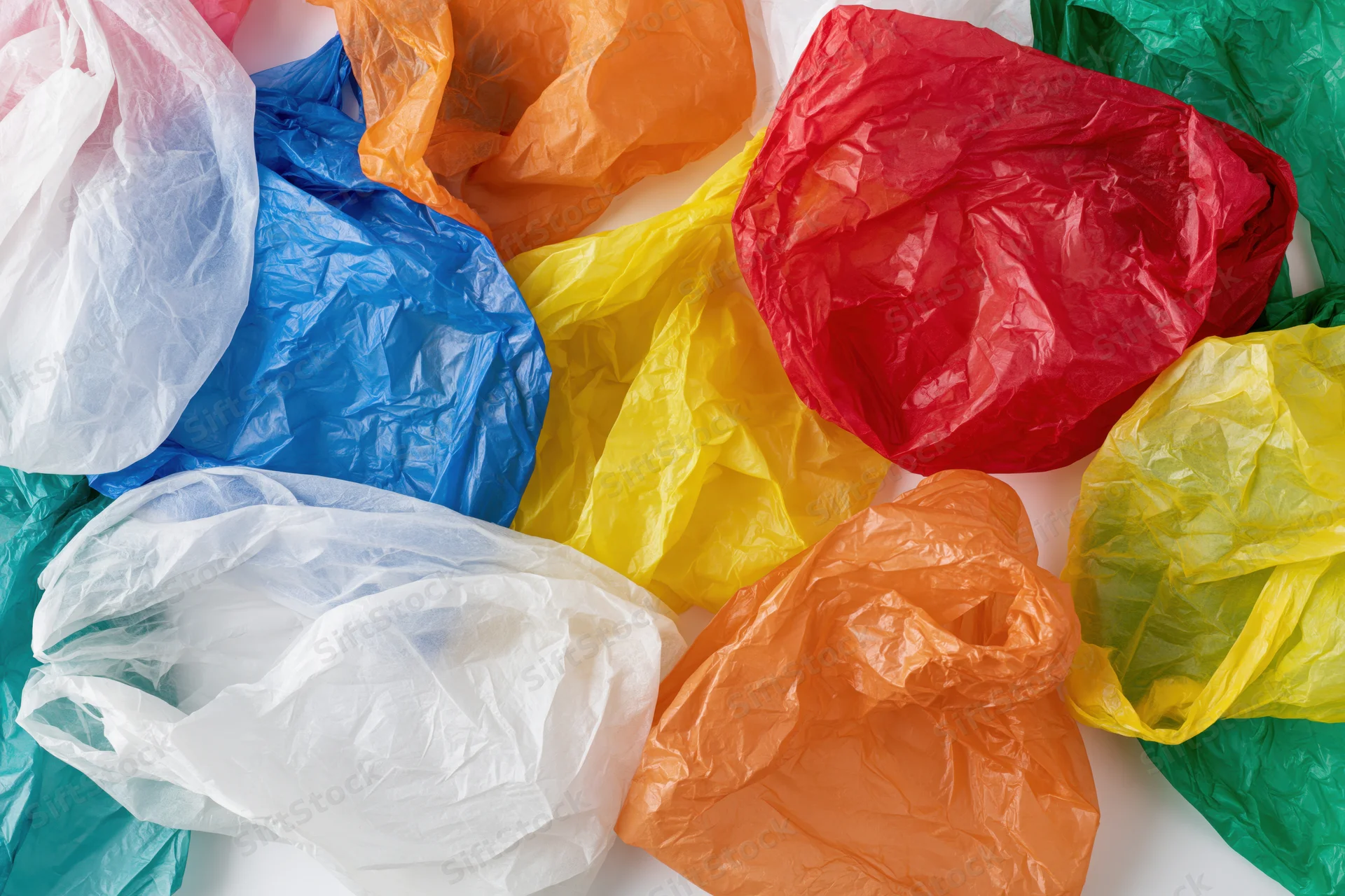 Crumpled plastic shopping bags scattered in a pile on white background