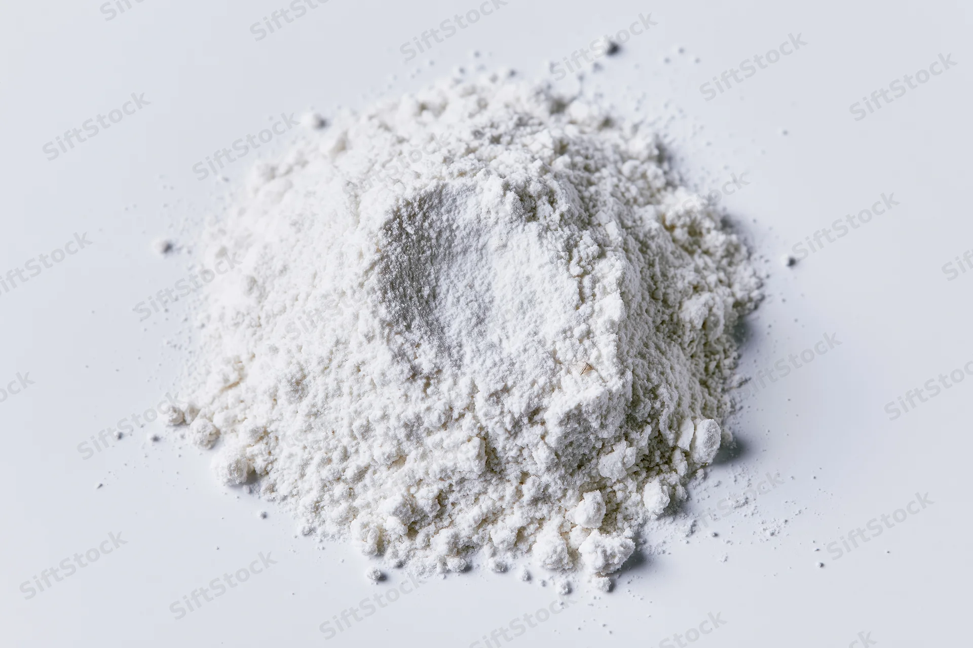 Loose pile of fine white powder on a plain white surface