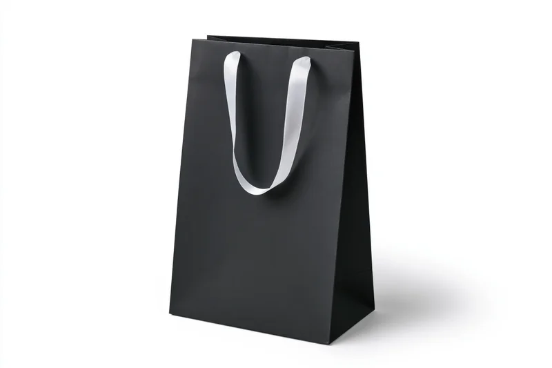 Matte black paper shopping bag with white ribbon handles on white background