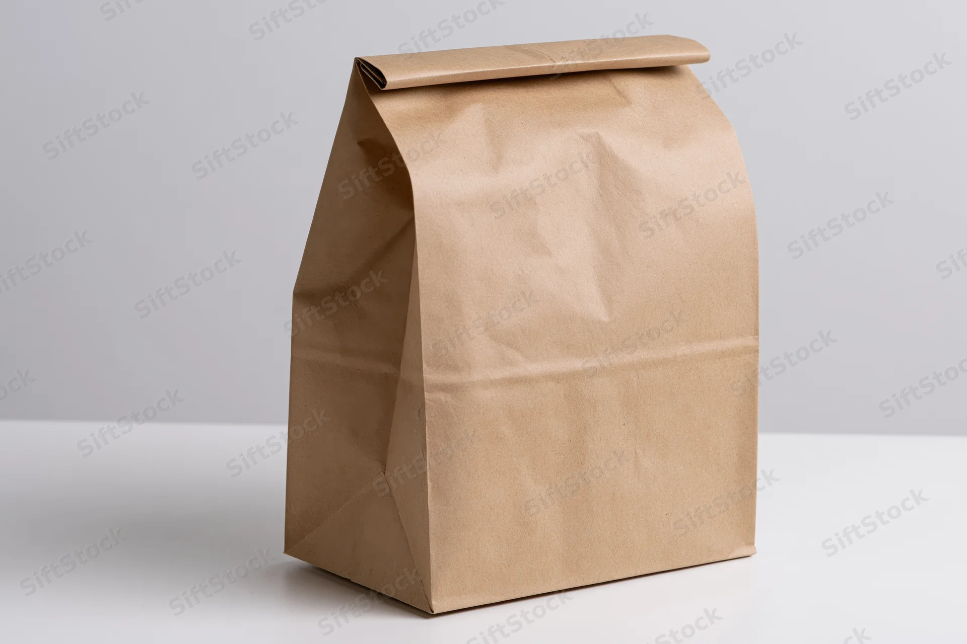 Plain kraft paper bag standing upright on white surface