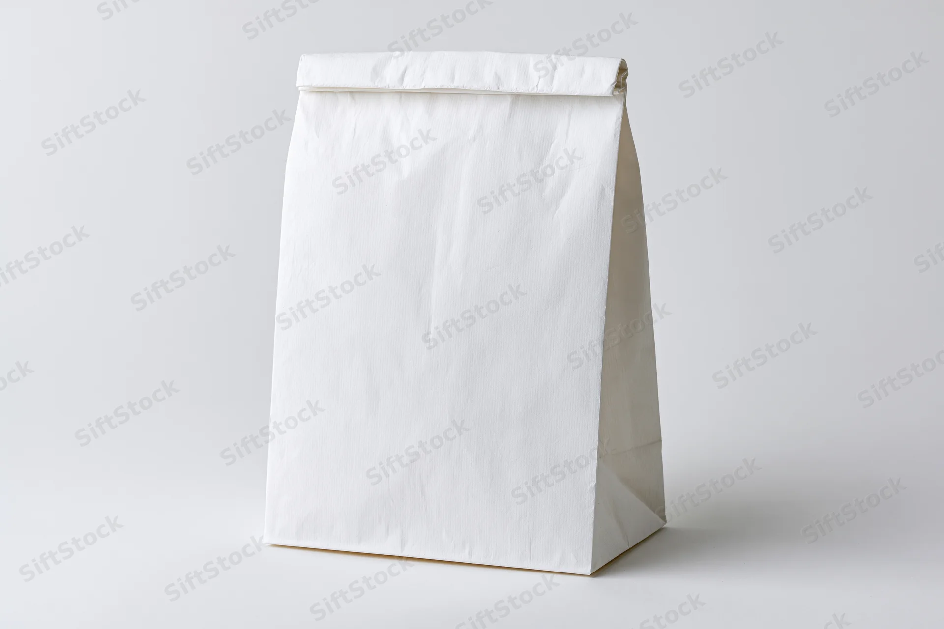 Plain white paper bag standing upright on a white surface