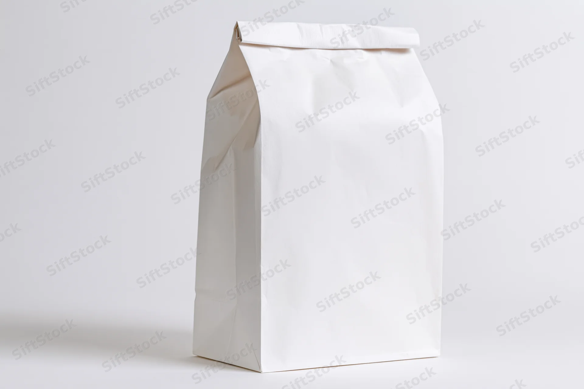 Plain white paper bag standing upright on a white surface