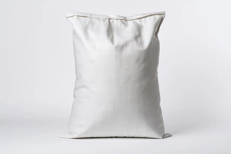 White woven polypropylene sack standing upright on plain white surface