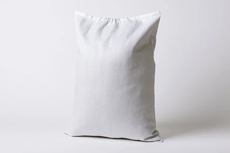 White woven polypropylene sack standing upright on plain background